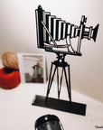 Steel decorative gift item featuring a professional camera with a stand