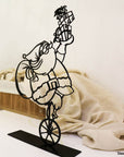 Steel decorative gift item featuring Santa Clause on a unicycle