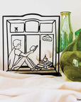 Steel decorative gift item featuring a man reading a book and drinking coffee