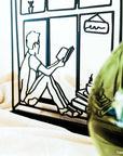 Steel decorative gift item featuring a man reading a book and drinking coffee