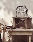 Steel decorative gift item featuring the faces of a man and woman
