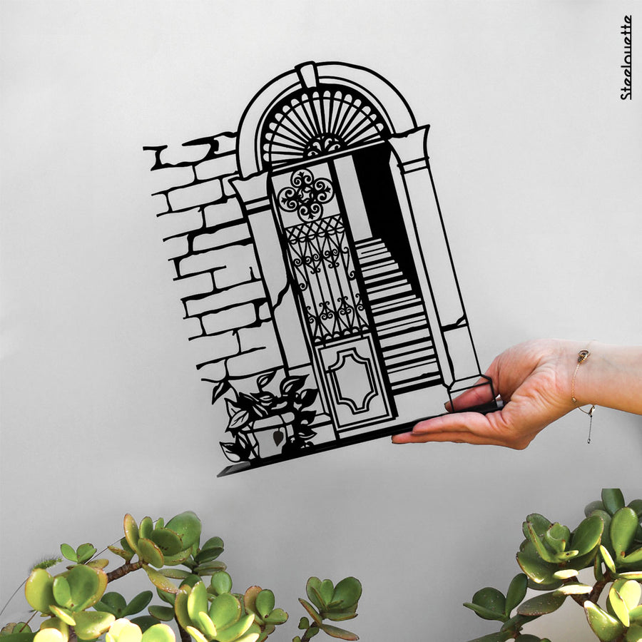 steel decorative gift item showcasing a traditional wall, door, and stairs