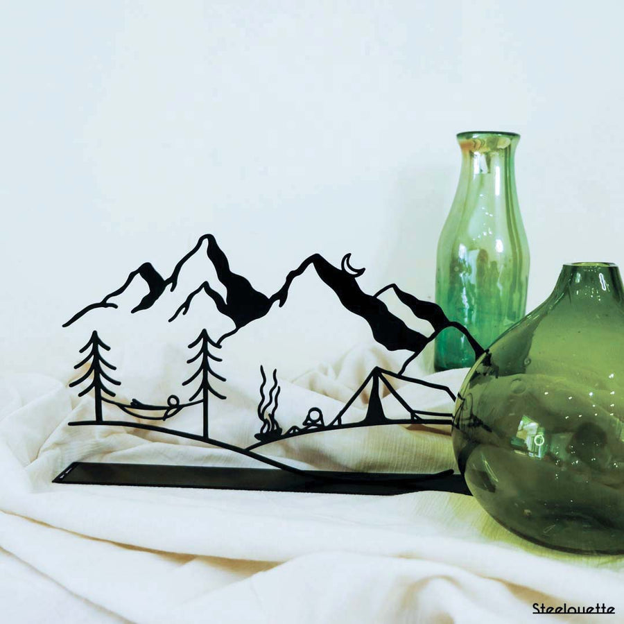 Steel decorative and gift item featuring a serene nature scene with trees, a hammock, mountains, and the moon.
