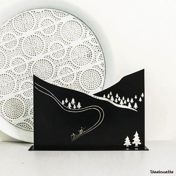 Steel decorative gift item featuring ski slopes and trees