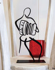 steel decorative gift item of a man playing on an accordion white and black borders