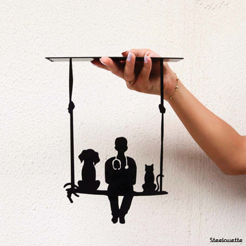 steel decorative gift item of a vet sitting between a cat and a dog