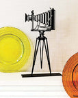 Steel decorative gift item featuring a professional camera with a stand