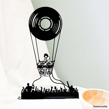 Steel decorative gift item featuring a cd as a parachute from which a dj is playing music and people are dancing and partying