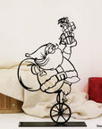 Steel decorative gift item featuring Santa Clause on a unicycle